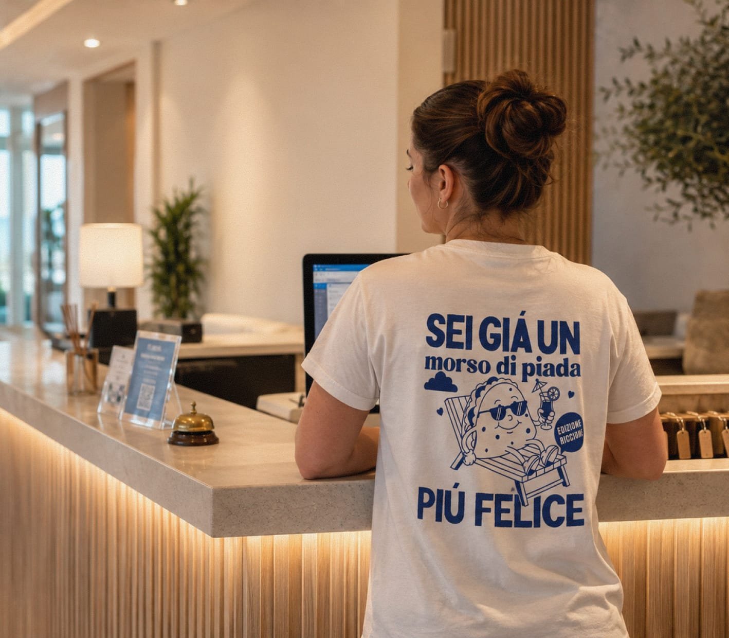 Woman wearing the blue Arlecchino Hotel t-shirt print at the hotel reception